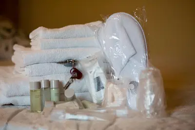 a pile of towels and hygiene products on a table at BQ House Castello Luxury Rooms in Rome