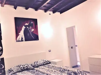 a bedroom with a bed and a picture on the wall at Casa Vacanze Colosseum by Serena in Rome