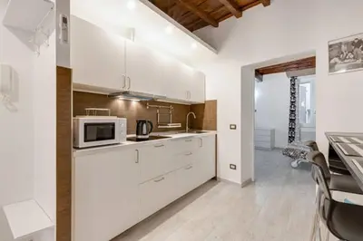 a kitchen with white cabinets and a microwave at Casa Vacanze Colosseum by Serena in Rome