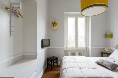 a white bedroom with two beds and a window at Guest House Poerio88 in Rome