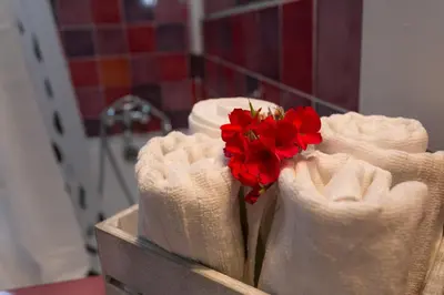 a row of white towels with red flowers in them at S.Angelo Terrace sq Navona in Rome