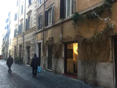 two people walking down a street next to a building at S.Angelo Terrace sq Navona in Rome