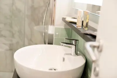 a bathroom with a white sink and a shower at Vittoriano Suite in Rome