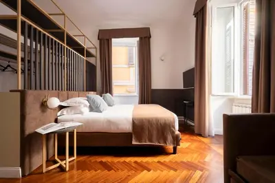 a bedroom with a large bed and a staircase at Vittoriano Suite in Rome
