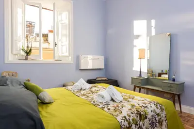 a bedroom with a yellow bed with towels on it at Casa Minerva Al Pantheon in Rome