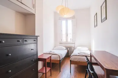 a room with a desk and a bed and a table at HC - Sunny Apartment in Testaccio! in Rome