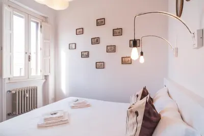 a white bedroom with a bed with a light fixture at HC - Sunny Apartment in Testaccio! in Rome