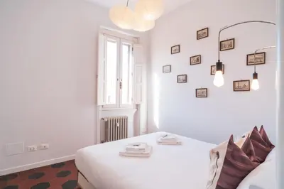 a white bedroom with a bed and a window at HC - Sunny Apartment in Testaccio! in Rome