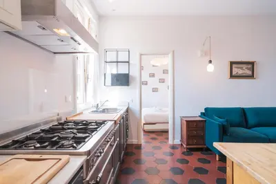a kitchen with a stove and a blue couch at HC - Sunny Apartment in Testaccio! in Rome