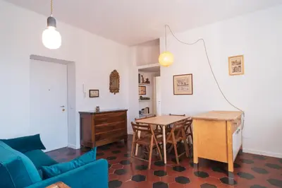 a living room with a table and a blue couch at HC - Sunny Apartment in Testaccio! in Rome