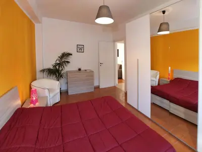 a bedroom with a red bed and a living room at Marina Home in Rome