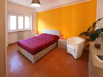 a bedroom with a red bed and a white chair at Marina Home in Rome