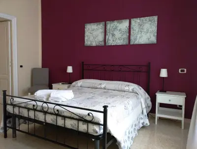 a bedroom with a bed with a purple wall at Capital Flat 9/b in Rome