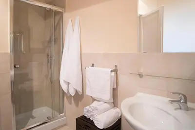 a bathroom with a sink and a shower with towels at Capital Flat 9/b in Rome
