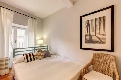 a bedroom with a bed and a chair and a window at Appartamento con vista sul Vittoriano in Rome