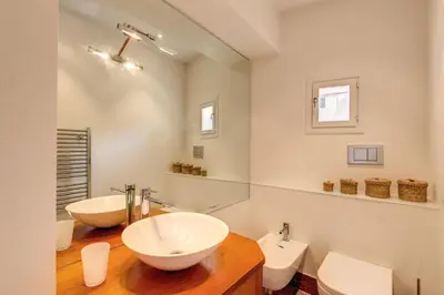 a bathroom with two sinks and a mirror at Appartamento con vista sul Vittoriano in Rome