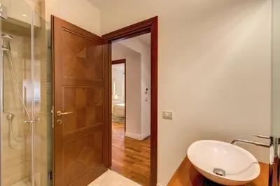a bathroom with a sink and a glass shower door at Appartamento con vista sul Vittoriano in Rome