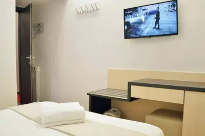 a room with a bed and a tv on the wall at KayDee GuestHouse in Rome