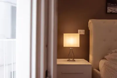 a lamp on a night stand next to a bed at Central Vatican Rooms in Rome
