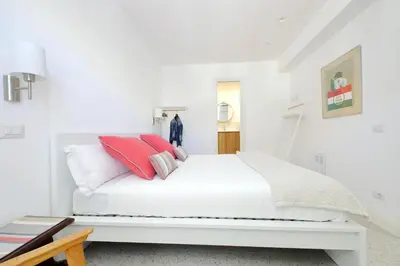 a white bedroom with a white bed with red pillows at YCH-Penthouse Fiammetta a Piazza Navona in Rome