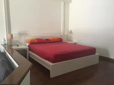 a bedroom with a bed with red sheets and orange pillows at Vatican City House Roma in Rome