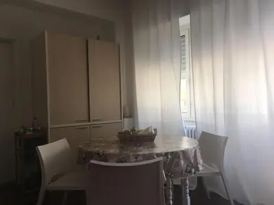 a dining room with a table and chairs and a cabinet at Vatican City House Roma in Rome