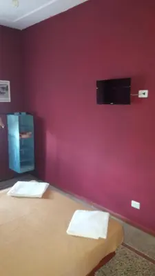 a room with a red wall with a flat screen tv at Art in Accommodation in Rome