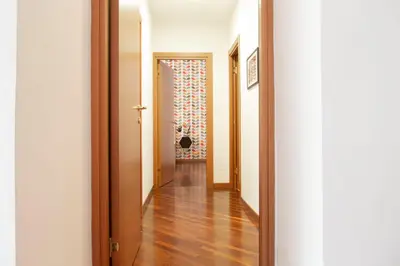 a hallway with wooden floors and white walls at TrastevereHome - Garibaldi Rome in Rome