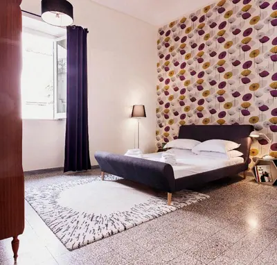 a bedroom with a bed in a room with a wall at TrastevereHome - Peretti Rome in Rome