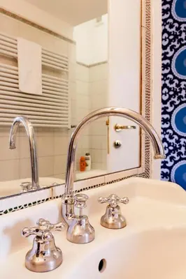 a bathroom sink with two faucets and a mirror at TrastevereHome - Secret Calisto Amazing View Trastevere Rooftops in Rome