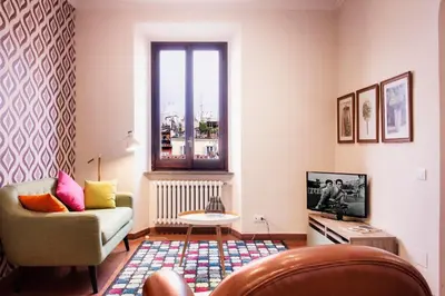 a living room with a couch and a tv at TrastevereHome - Secret Calisto Amazing View Trastevere Rooftops in Rome