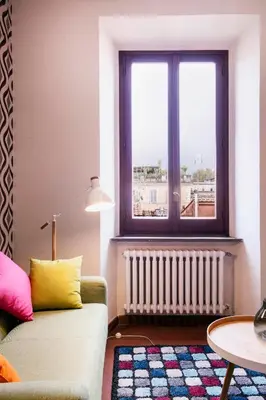 a living room with a couch and a window at TrastevereHome - Secret Calisto Amazing View Trastevere Rooftops in Rome