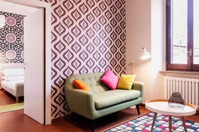 a living room with a chair with colorful pillows at TrastevereHome - Secret Calisto Amazing View Trastevere Rooftops in Rome
