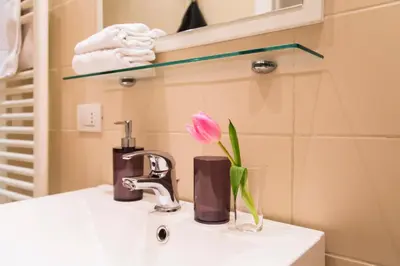 a pink flower in a vase on a bathroom sink at TrastevereHome - Paglia House of 17Century in Trastevere in Rome