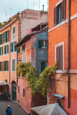 a woman walking down a street in an old building at TrastevereHome - Paglia House of 17Century in Trastevere in Rome