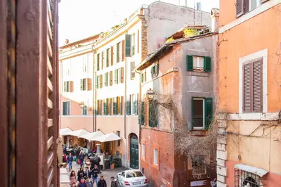 a group of people walking down a street with buildings at TrastevereHome - Paglia House of 17Century in Trastevere in Rome