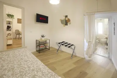a white room with a bed and a mirror at Buongiorno Colosseo in Rome