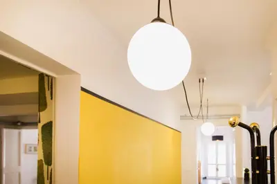a light hanging from a ceiling with a yellow wall at TrastevereHome - Ripa Rome Trastevere Home in Rome