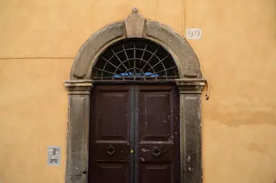 a brown door with an arch above it on a building at TrastevereHome - Ripa Rome Trastevere Home in Rome