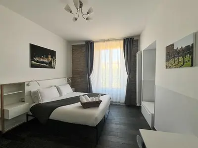a bedroom with a large bed and a window at Arch Rome Suites in Rome