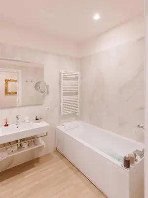 a white bathroom with a tub and a sink at Rhea Silvia Luxury Navona in Rome
