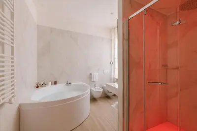 a white bathroom with a tub and a shower at Rhea Silvia Luxury Navona in Rome