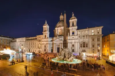 a large building with a fountain in front of it at night at Rhea Silvia Luxury Navona in Rome