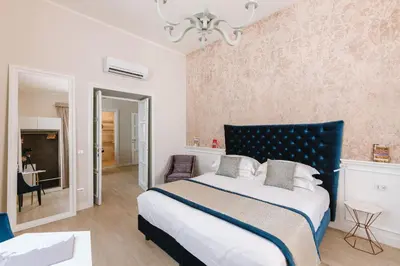 a bedroom with a large bed with a blue headboard at Rhea Silvia Luxury Navona in Rome