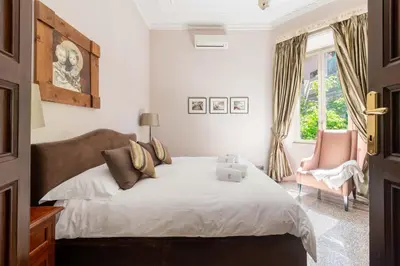 a bedroom with a bed and a chair and a window at Popologrande Apartment in Rome