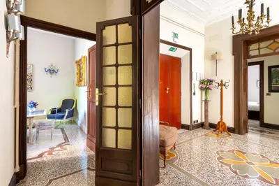 a hallway with a door and a room with a chair at Popologrande Apartment in Rome