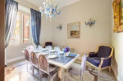 a dining room with a table and chairs and a chandelier at Popologrande Apartment in Rome