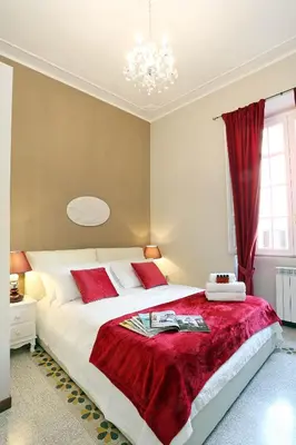 a bedroom with a large bed with a red blanket at Liberty Rome Apartment - Liberty Collection in Rome