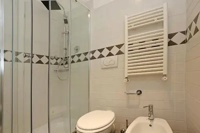 a bathroom with a toilet and a glass shower at Liberty Rome Apartment - Liberty Collection in Rome