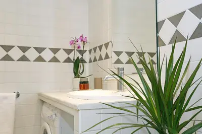 a bathroom with a sink and a potted plant at Liberty Rome Apartment - Liberty Collection in Rome